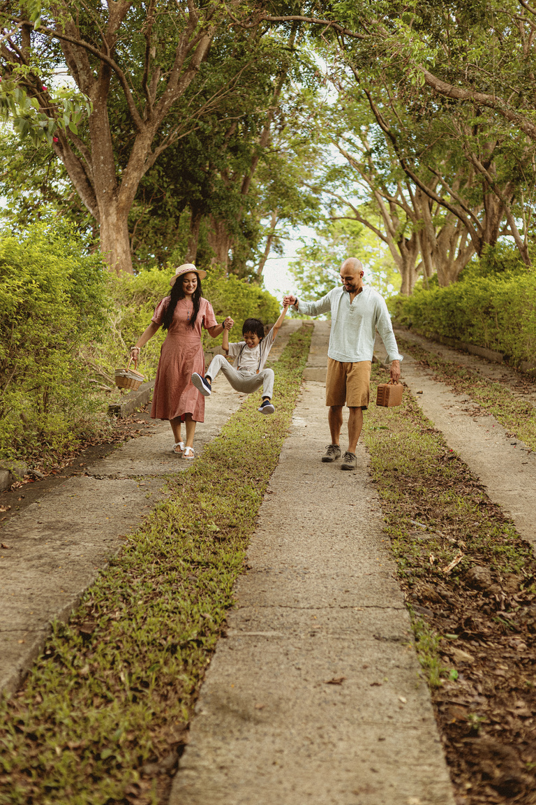 Family of Three Walking Together on Footpath Outdoors